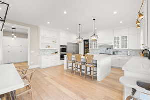 Kitchen with a sink, a center island, tasteful backsplash, appliances with stainless steel finishes, and a breakfast bar area