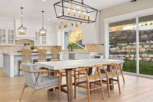 Dining area with recessed lighting, light wood-style floors, and a notable chandelier