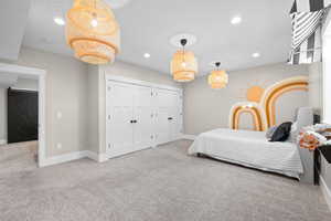 Carpeted bedroom featuring two closets, baseboards, and recessed lighting