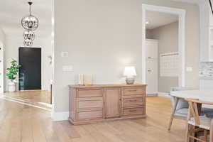 Interior space featuring baseboards, a chandelier, light wood-style floors, and recessed lighting