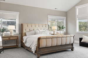 Bedroom featuring lofted ceiling, visible vents, carpet flooring, and baseboards