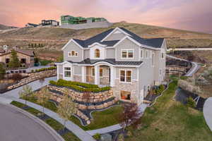 Modern farmhouse with a standing seam roof, a mountain view, stone siding, metal roof, and board and batten siding
