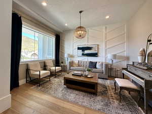 Living room featuring recessed lighting, baseboards, a chandelier, a textured ceiling, and hardwood / wood-style flooring