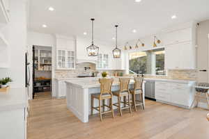 Kitchen with stainless steel dishwasher and white cabinetry