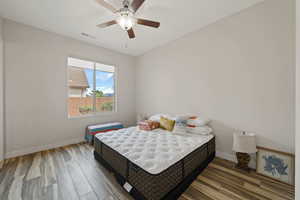 Bedroom featuring wood finished floors, visible vents, a ceiling fan, and baseboards