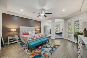 Bedroom with light wood-type flooring, baseboards, and access to outside