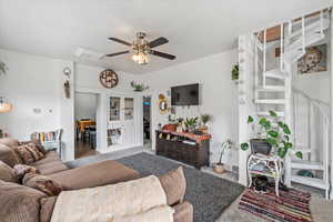 Carpeted living area with a ceiling fan and visible vents