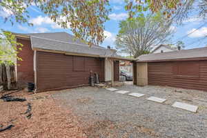Rear view of house with a shingled roof and fence