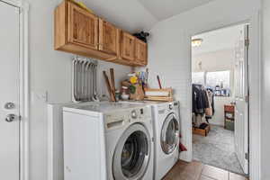 Laundry room featuring cabinet space, tile patterned flooring, carpet flooring, and washer and dryer
