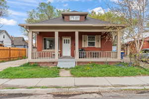 Bungalow-style house featuring a porch and fence