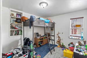 Bedroom with carpet and a textured ceiling
