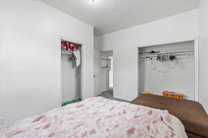 Carpeted bedroom with baseboards and a textured ceiling
