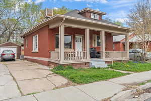 View of front of home featuring central AC, driveway, an outdoor structure, a detached garage, and a porch