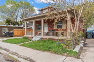 View of front of house featuring fence and a porch