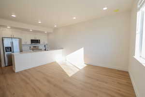 Kitchen with recessed lighting, light wood finished floors, stainless steel appliances, and a sink