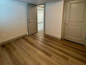 Finished below grade area featuring wood finished floors, a textured ceiling, and baseboards