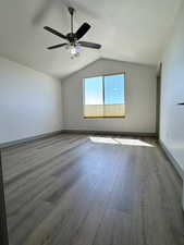 Master Bedroom Unfurnished room with vaulted ceiling, a ceiling fan, baseboards, and wood finished floors