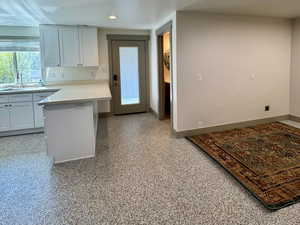 Kitchen with baseboards, a textured ceiling, and a sink