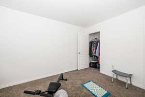 Workout room featuring baseboards and carpet