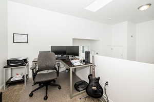 Third level Office featuring a skylight, baseboards, and carpet