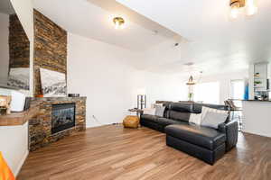Living room featuring baseboards, wood finished floors, visible vents, and a fireplace