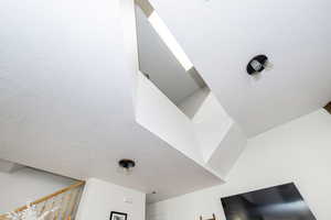 Skylight through home, view from level 1. Room details with a textured ceiling