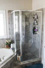 Bathroom featuring a bath, a shower stall, and plenty of natural light