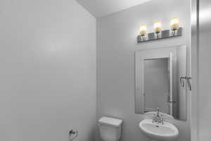 Main floor half bathroom, privately situated around the corner from the kitchen.