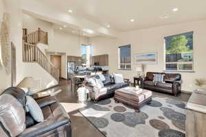 Living area with finished concrete flooring, stairs, and recessed lighting