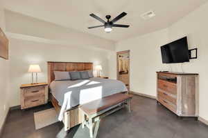 Primary Bedroom featuring, ensuite bath, baseboards, finished concrete floors, and ceiling fan