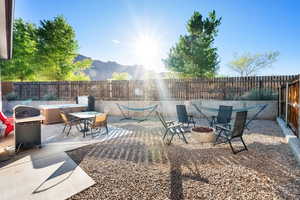View of patio with a fenced backyard, an outdoor fire pit, outdoor dining area, and a mountain view