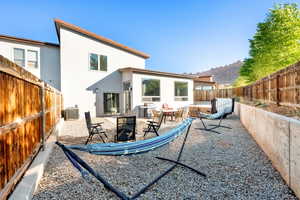 Back of property featuring stucco, a patio area, a fenced backyard, and central AC
