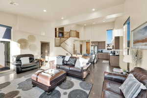 Living area with a high ceiling,  recessed lighting, and stairs