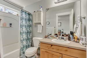 Full bath featuring toilet, vanity, and shower / bath combo with shower curtain