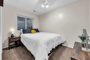 Bedroom with baseboards, visible vents, and carpet