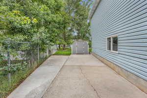 View of patio / terrace with a storage shed, a fenced backyard, and an outdoor structure