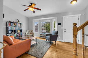 Living room featuring light wood-style floors, stairway, a ceiling fan, and baseboards
