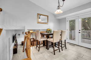 Dining area featuring lofted ceiling, visible vents, and french doors