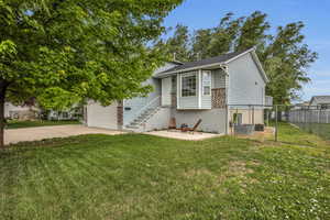 View of front of home featuring a garage, a front yard, concrete driveway, and fence