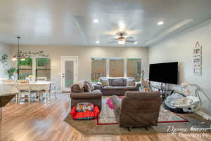 Living room with recessed lighting, light wood-style floors, baseboards, and ceiling fan