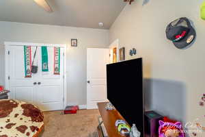 Carpeted bedroom featuring a ceiling fan