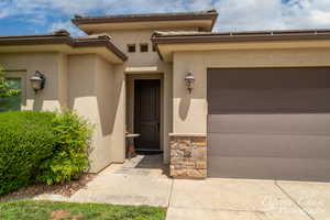 Doorway to property featuring stucco siding and an attached garage