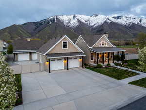 View of front of property with a standing seam roof, a gate, metal roof, fence, and covered porch
