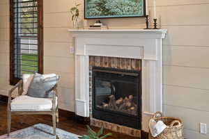 Details featuring a brick fireplace and wood finished floors