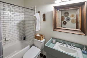 Full bathroom with toilet, vanity, and bathing tub / shower combination