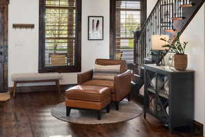 Living area with baseboards, stairs, and hardwood / wood-style flooring