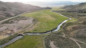 Aerial view of property and surrounding area with a water and mountain view