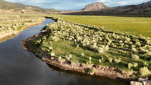 Aerial view of property and surrounding area with rural landscape and a water and mountain view