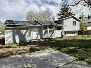 View of front of home featuring fence, a patio area, and a chimney