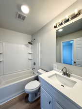 Bathroom with wood finished floors, vanity, toilet, visible vents, and bathing tub / shower combination